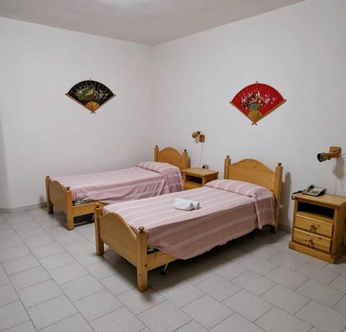 una camera con due letti e due comodini di Hotel Panorama a Badesi