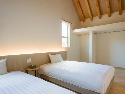 two beds in a small room with a window at Rakuten STAY VILLA Kinugawa Riverside in Nikko