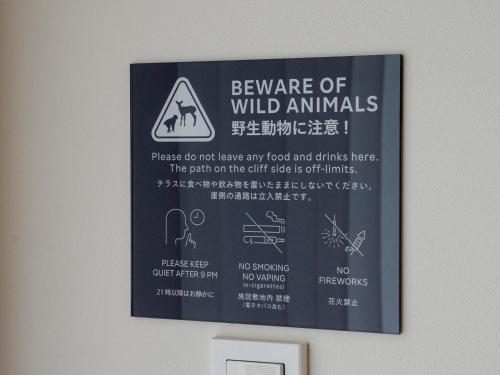 a sign on a wall that says beware of wild animals at Rakuten STAY VILLA Kinugawa Riverside in Nikko