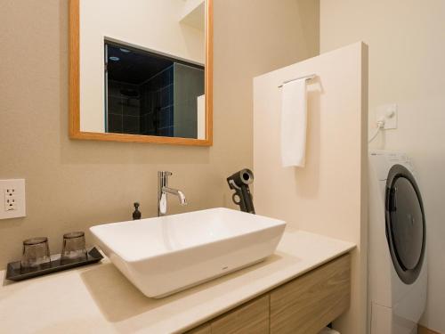 a bathroom with a white sink and a mirror at Rakuten STAY VILLA Kinugawa Riverside in Nikko
