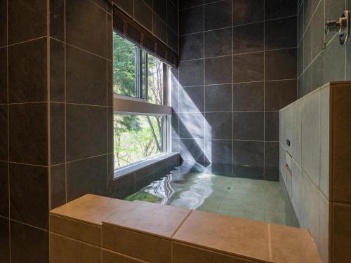 a bathroom with a window and a bath tub at Rakuten STAY VILLA Kinugawa Riverside in Nikko