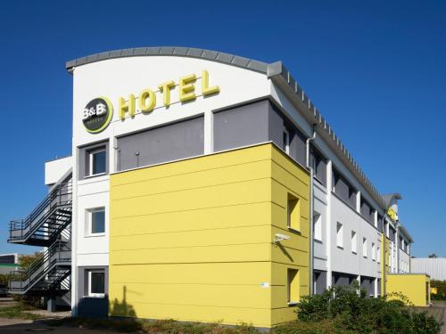 hotel z żółto-białym budynkiem w obiekcie B&B Hotel Leipzig-Nord w Lipsku