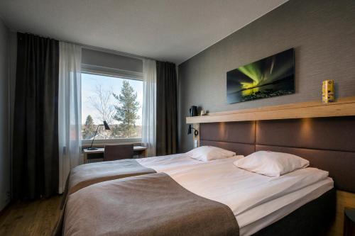 a hotel room with a large bed and a window at Hotelli Toivola in Kemi