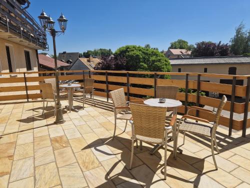 a patio with tables and chairs and a fence at Bed & Breakfast Hotel Müllerhof in Caputh