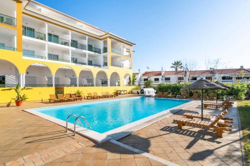 a swimming pool in front of a building at Apartamentos Turisticos Alagoa Praia in Altura