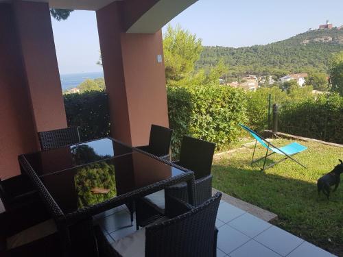 une maison avec vue sur une cour avec un chien dans l'établissement Cap Esterel Ile d'or dans Village de vacances, à Saint-Raphaël