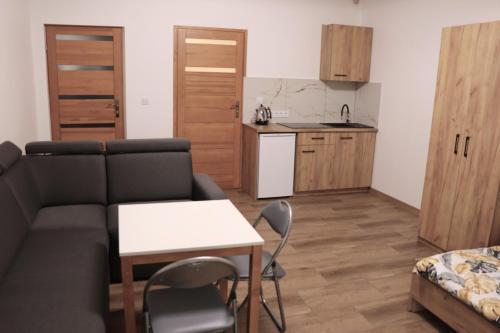 a living room with a couch and a table and a kitchen at Apartamenty Zator Energy Rest in Zator