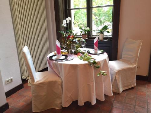 a table with two chairs and a table with flowers and candles at Schlosshotel Bredenfelde in Bredenfelde