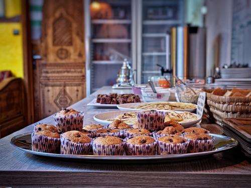 Surf hostel Morocco في Tamraght Ouzdar: طاولة عليها كعك وغيرها من الحلويات