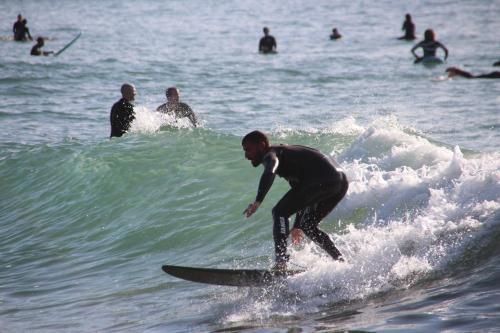 a man riding a wave on a surfboard in the ocean at Surf hostel Morocco in Tamraght Ouzdar