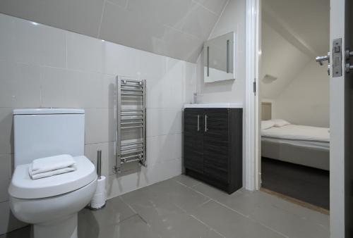 bagno bianco con servizi igienici e lavandino di Charlotte Street Rooms by News Hotel a Londra