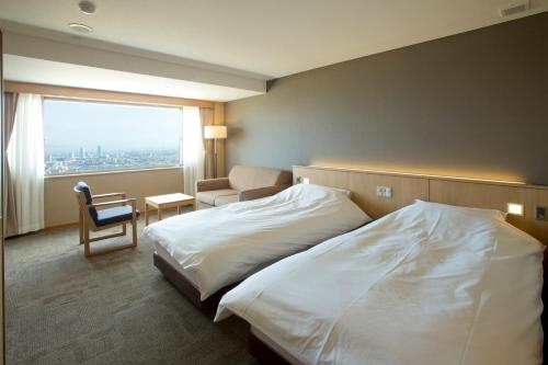 a hotel room with a bed and a chair and a window at 山荘 風の杜 Sanso Kazenomori in Minoo