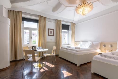 een slaapkamer met een groot bed en een tafel en stoelen bij Best Western Hotel Strasser in Graz