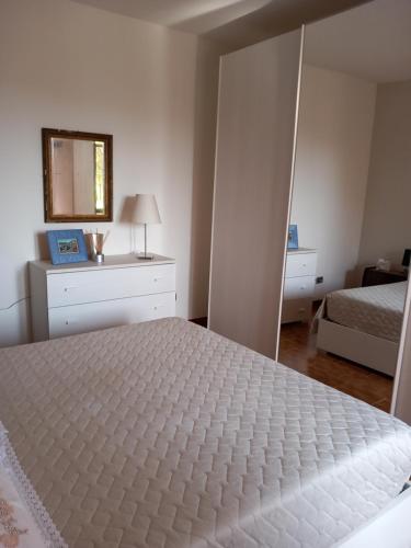 1 dormitorio con cama blanca y espejo en Casa Pachia, en Saló