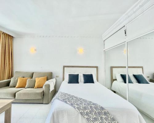 a bedroom with two beds and a couch at Estudio en primera línea de playa in Fuengirola