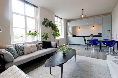 sala de estar con sofá, mesa y cocina en Ruim appartement in monumentaal gebouw, en Vianen