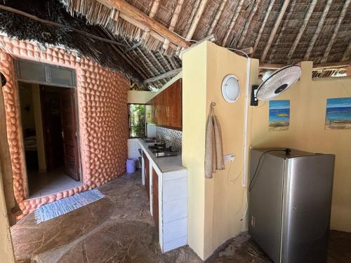 a kitchen with a sink and a refrigerator at Joe's poolhouse in Mombasa