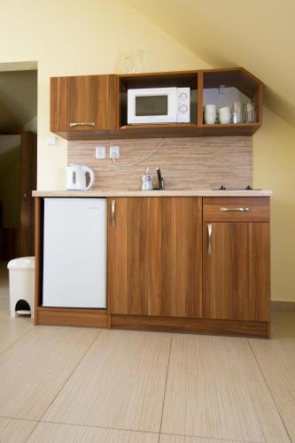 a kitchen with a white refrigerator and a microwave at Penzion Admirál in Třeboň