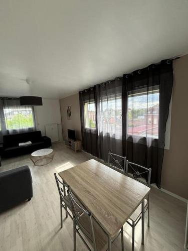 un salon avec une table et un canapé dans l'établissement 1 chambre proche du centre-ville, à Douai