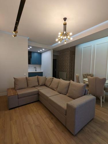 a living room with a couch and a dining room at Suites In Tbilisi Hilton Apartment in Tbilisi City