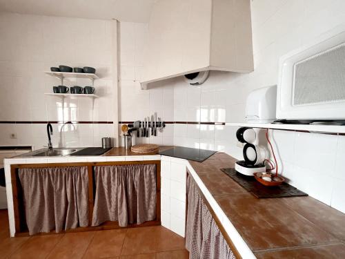 a kitchen with a sink and a microwave at Casa Rural Pernales I in Ruidera