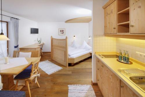 a kitchen and living room with a table and a bed at Pension Hochvogel in Bad Hindelang