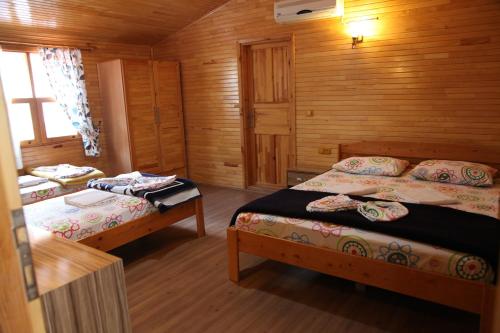 a bedroom with two beds in a wooden cabin at Olympos Varuna Pansiyon in Olympos