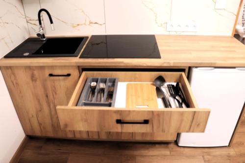 a kitchen with a sink and a wooden drawer at Apartamenty Zator Energy Rest in Zator