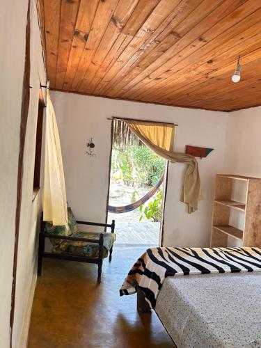 1 dormitorio con cama y techo de madera en Pousada Roy Bonete, en Ilhabela