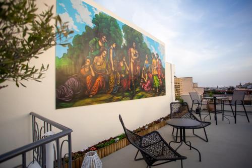 a large painting on a wall with chairs and tables at Ourania by Heloni Apartments in Athens
