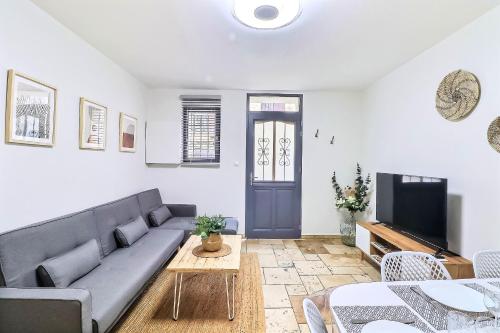 un salon avec un canapé et une télévision dans l'établissement LE LOGY-COSY - Appartement 5 pers - Clim Wifi Cosy Garage, à Saint-Gilles