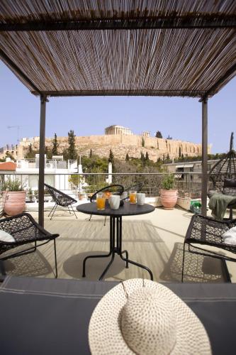 a table and chairs on a patio with a view at Ourania by Heloni Apartments in Athens