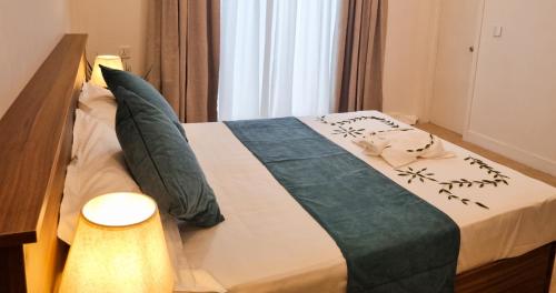 a bedroom with a bed with a blue and white blanket at Vaagali Inn in Keyodhoo