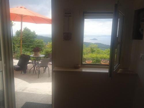 a door leading to a patio with a table and an umbrella at Virginia house in Montefiascone
