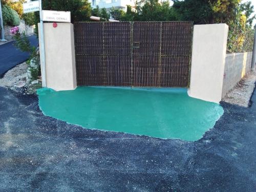 a pool of green water next to a fence at Villa M Cako in Ksamil