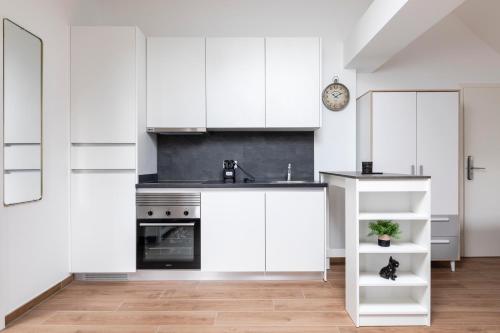 a white kitchen with white cabinets and a sink at IMMOBILIARE Lux Tram in Luxembourg