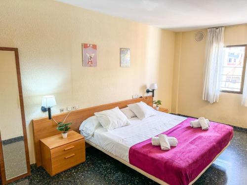 a bedroom with a large bed with two towels on it at Duplex del Mar Castellon ComoTuCasa in Castellón de la Plana