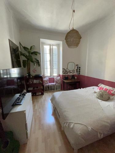 une chambre avec un grand lit blanc et une table dans l'établissement Grand appartement port de Nice, à Nice