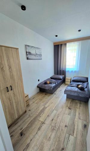 a living room with two beds and a wooden floor at Zebrzydowicka 37 in Rybnik