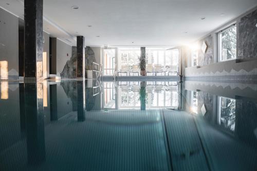 a room with a swimming pool in a building at Genusshotel Fichtenhof in Grossarl