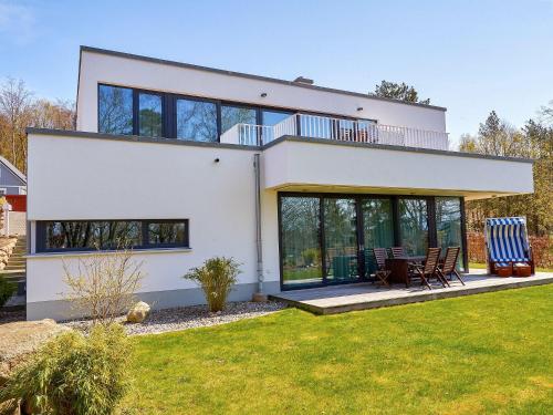 une maison avec de grandes fenêtres et une pelouse dans l'établissement Haus Wetterhexe - FeWo 02, à Sellin