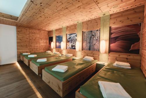 Zimmer mit 4 Betten in einem Holzzimmer in der Unterkunft Genusshotel Fichtenhof in Großarl