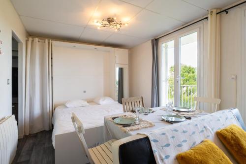une salle à manger avec une table et un lit dans l'établissement Grand studio cabine lumineux à 800m de la mer, à La Croix-Valmer