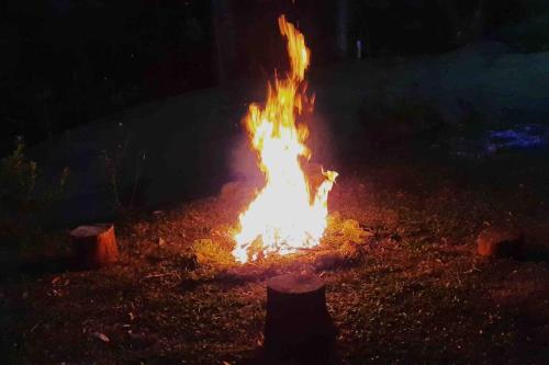 a fire burns in the yard at night at Casa Cipreste no Refúgio Pinheiro Beira Rio in Sapucaí-Mirim