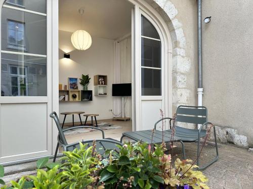 un patio avec deux chaises et une table et quelques plantes dans l'établissement L'Équinoxe - Cœur de ville avec terrasse, à Chartres