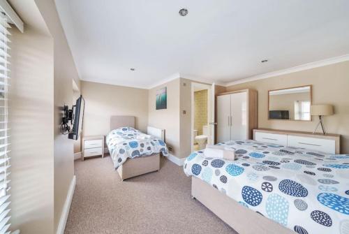 Un dormitorio con dos camas y un espejo. en Georgian Town House, en Ilfracombe