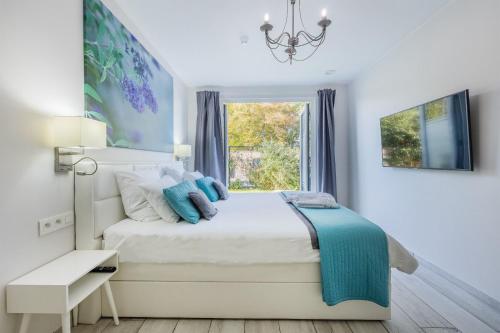 a white bedroom with a bed and a window at Vakantievilla - B&B Blue Garden Vlaamse Ardennen in Geraardsbergen