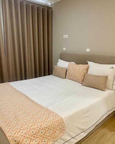 a bedroom with a large white bed with curtains at Hotel Neptuno in Peniche