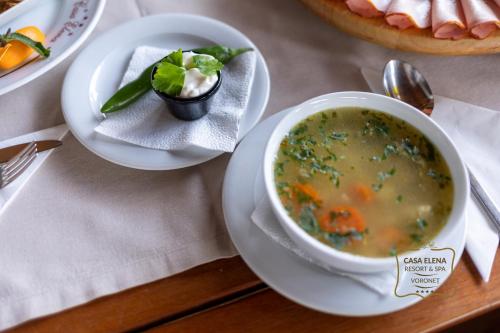 a bowl of soup on a table with a plate of food at Casa Elena - Resort & SPA in Voronet