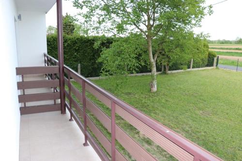 a porch with a fence and a green yard at Apartamenty Zator Energy Rest in Zator